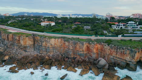 aerial coastal resort town placed on stone cliff shore. road on rocky shoreline.