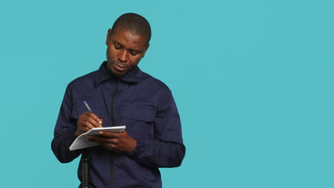 portrait of bodyguard using pen, documenting orders on notepad