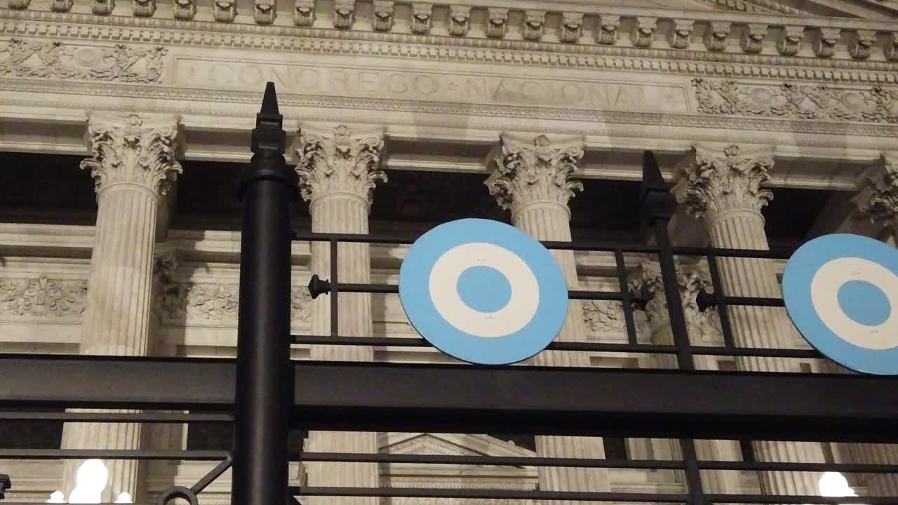 Veduta notturna dal basso della facciata del Palazzo del Congresso Nazionale con simboli della coccarda argentina.