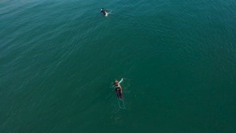 surfer girl paddling on a surfboard on turquoise water on a calm sea, pichilemu, chile-4k