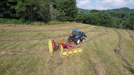 tractor-pulling-hay-rake-in-field-aerial