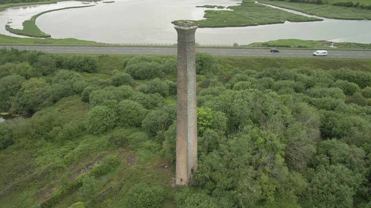 Aerial View of an Old Brick Chimney in a Lush Green Landscape