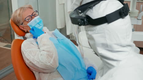 una mujer con máscara se queja de dientes doloridos por la covid-19