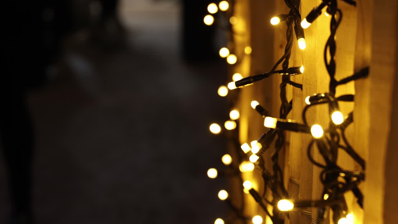 Fairy Christmas lights background with people walking by