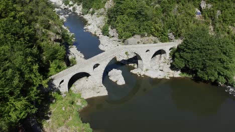 drone panning from the left to the right side of the frame above the devil's bridge in the town of ardino near the rhodope mountains in bulgaria