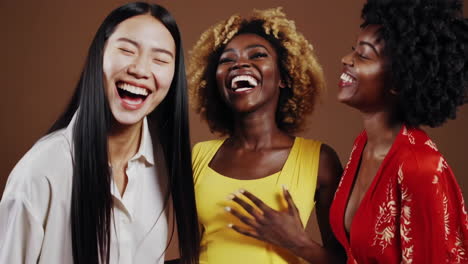 three diverse women laughing together