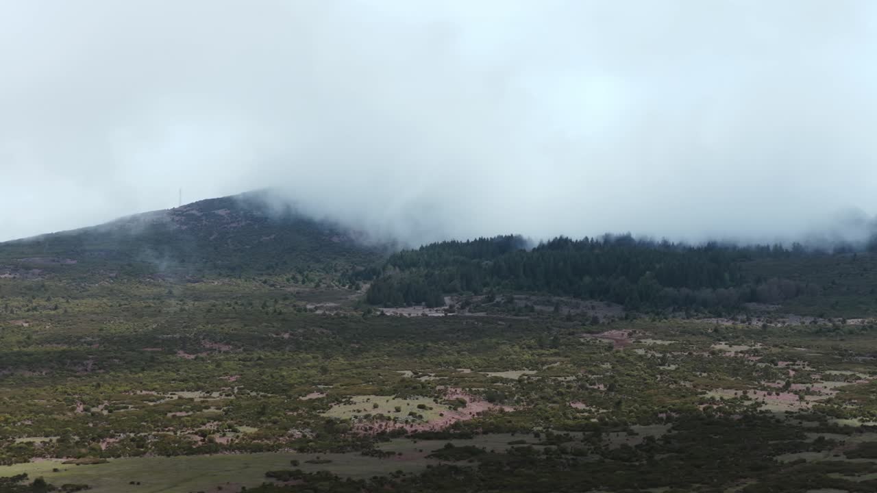 Rugged mountain landscape partially covered in mist, Pico Fernandez, Madeira, Portugal. Aerial drone, low flight, copy space