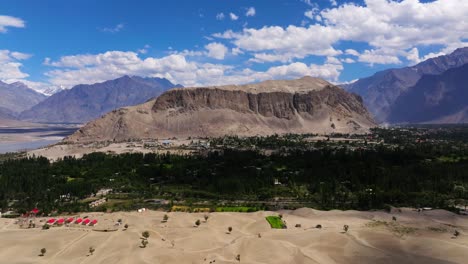 aerial view of oasis in the desert with mountains in the background