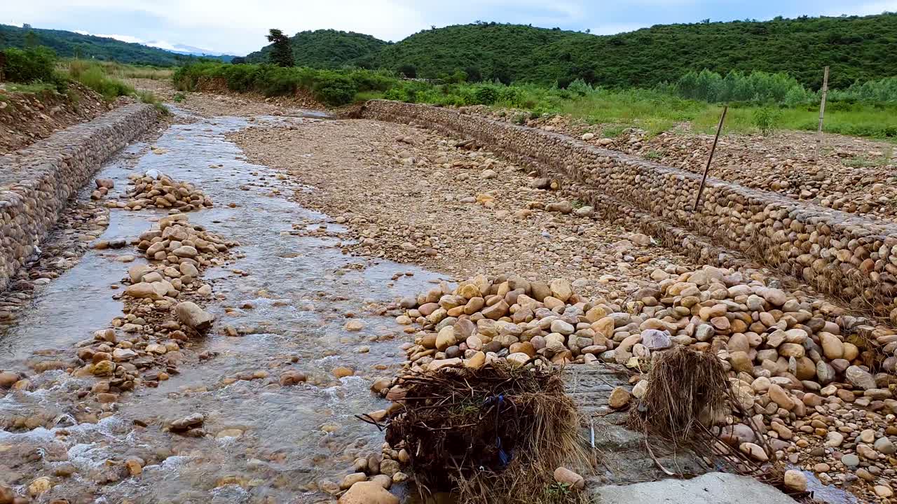 장마철에 녹색 산 가운데 바위 개울을 흐르는 빗물