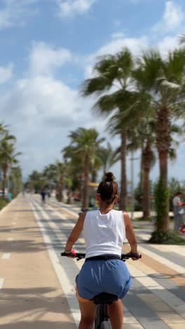 woman cycling along a coastal bike path