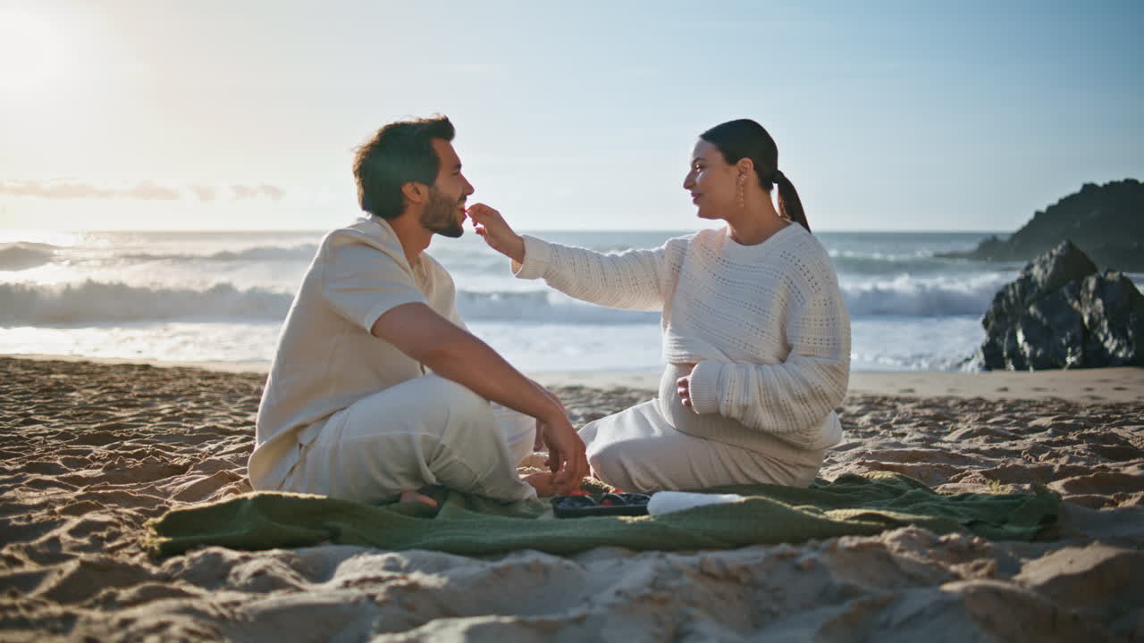 아기를 기대하는 부부는 바가에서 조용한 저녁 피크닉을 즐기고 있습니다. 임신 부부는