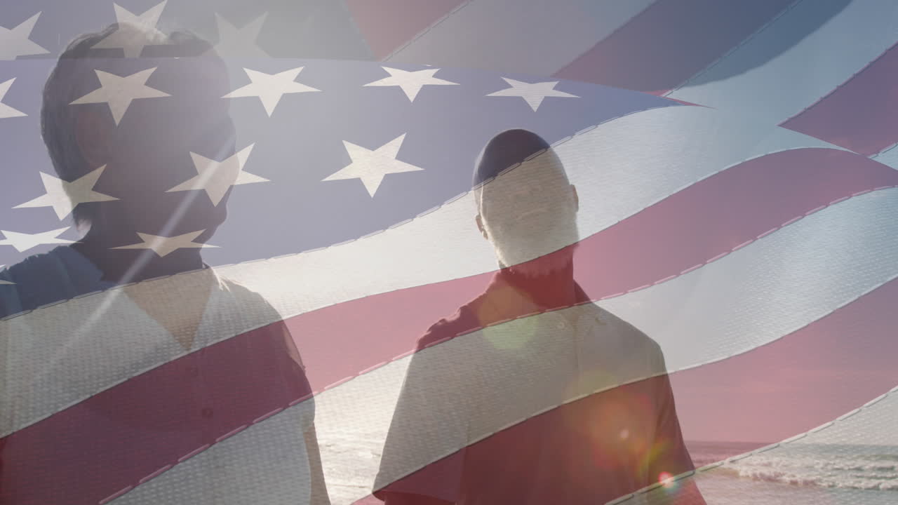 animación de la bandera de los ee.uu. sobre una feliz pareja biracial enamorada caminando por la playa