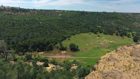 Aerial-fly-through-between-clifftop-trees-exposing-rural-highway-36-in-Tehama-County,-Northern-California