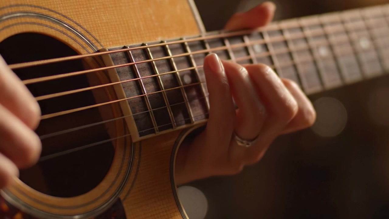 Un'esplorazione ravvicinata delle tecniche di chitarra: corde, dita e melodie catturate in azione durante un'esibizione musicale.