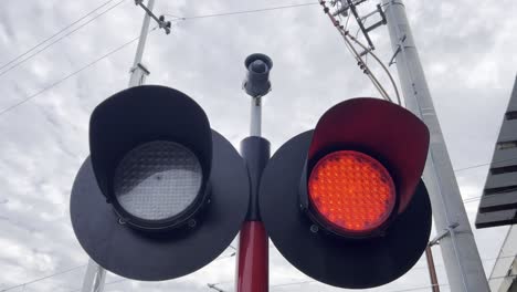 red traffic light on pole in sky with electric blue clouds. a close up of a red traffic light on a pole, signaling device, situated against the electric blue sky