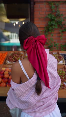 mujer comprando frutas en un mercado
