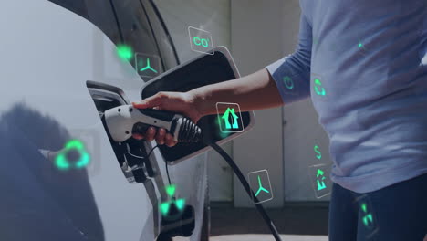 animation of energy and ecology icons over caucasian man charging electric car