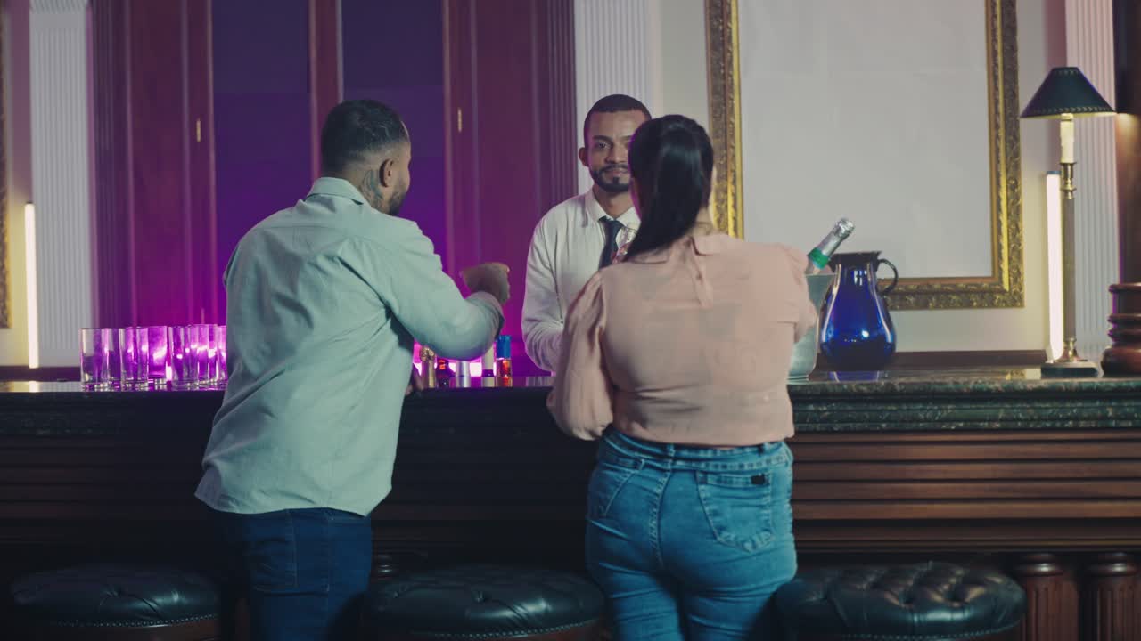 People socializing and interacting with a bartender at a bar