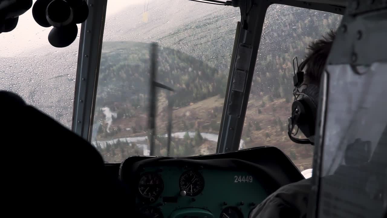 비가 오는 산악 지형 위 의 헬리터 비행