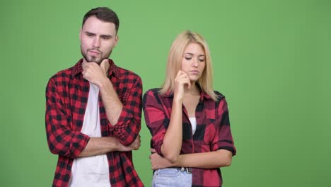 young couple thinking while looking down together