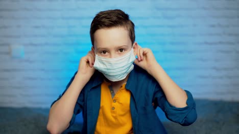 boy wearing medical face mask. self isolation. covid-19 virus epidemic pandemic. social distancing. health concept
