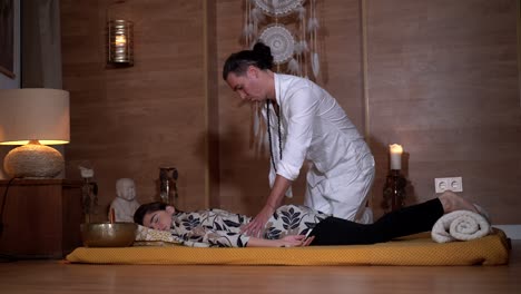 Spiritual-therapist-massaging-back-of-relaxed-woman