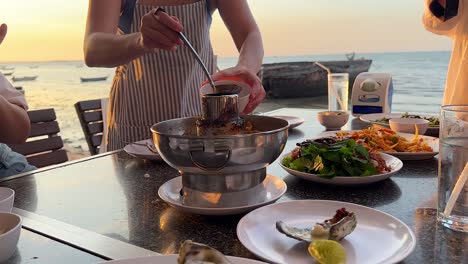 cooking and serving seafood at sunset by the sea