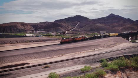 A-train-arrives-in-El-Paso,-Texas-after-exiting-the-mountains-of-New-Mexico