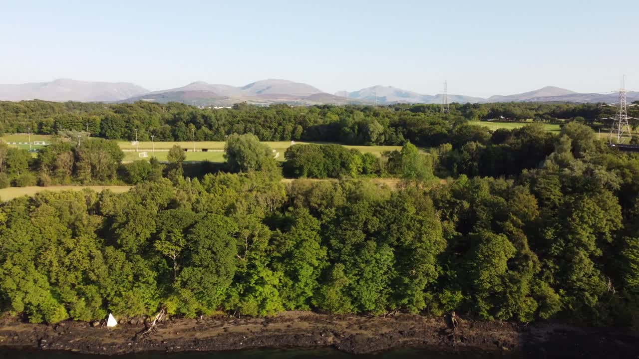 Snowdonia mountain range countryside aerial view with scenic Welsh farming landscape woodland trees next to river