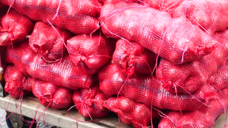 stack of red onion in bags