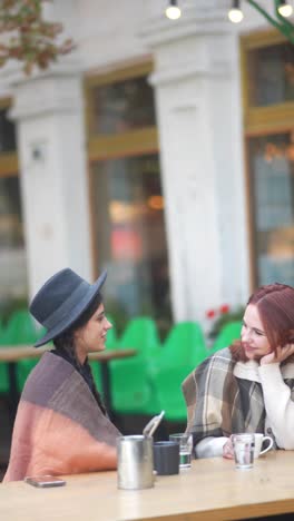 two women chatting at an outdoor cafe