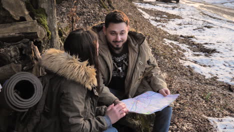 caucasian couple checking map in a forest.