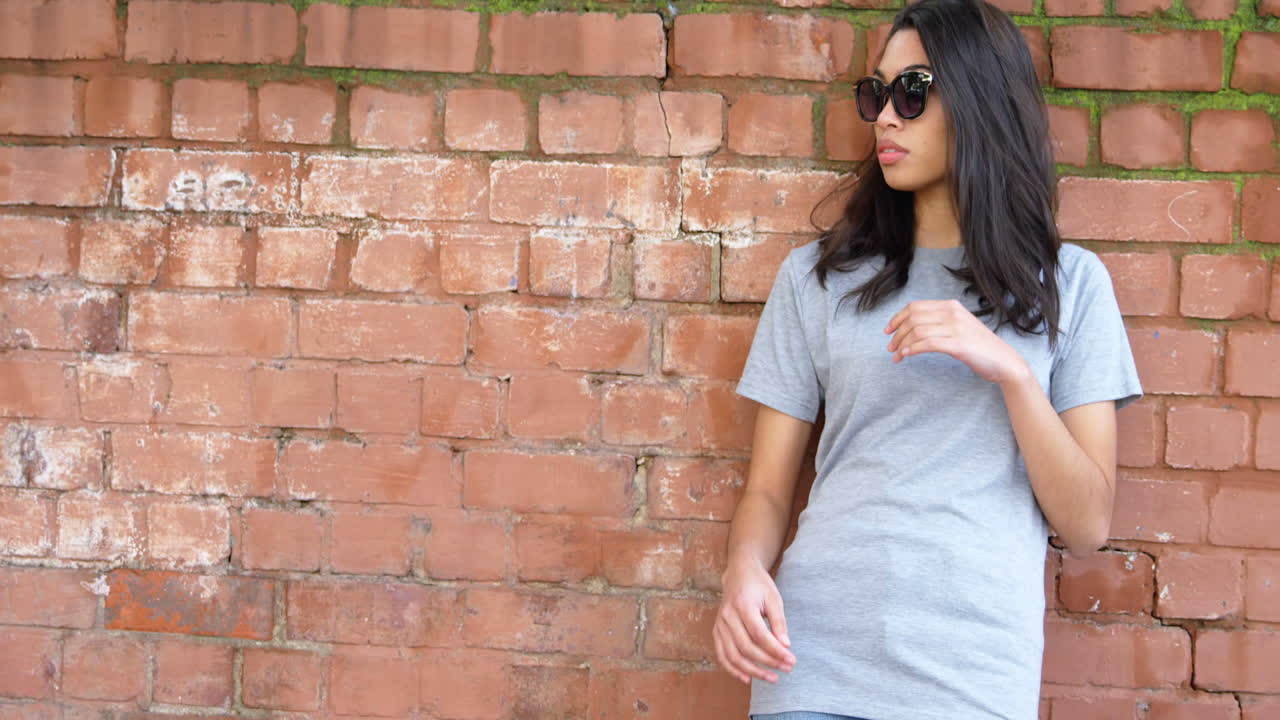 mujer joven de pie contra la pared 4k