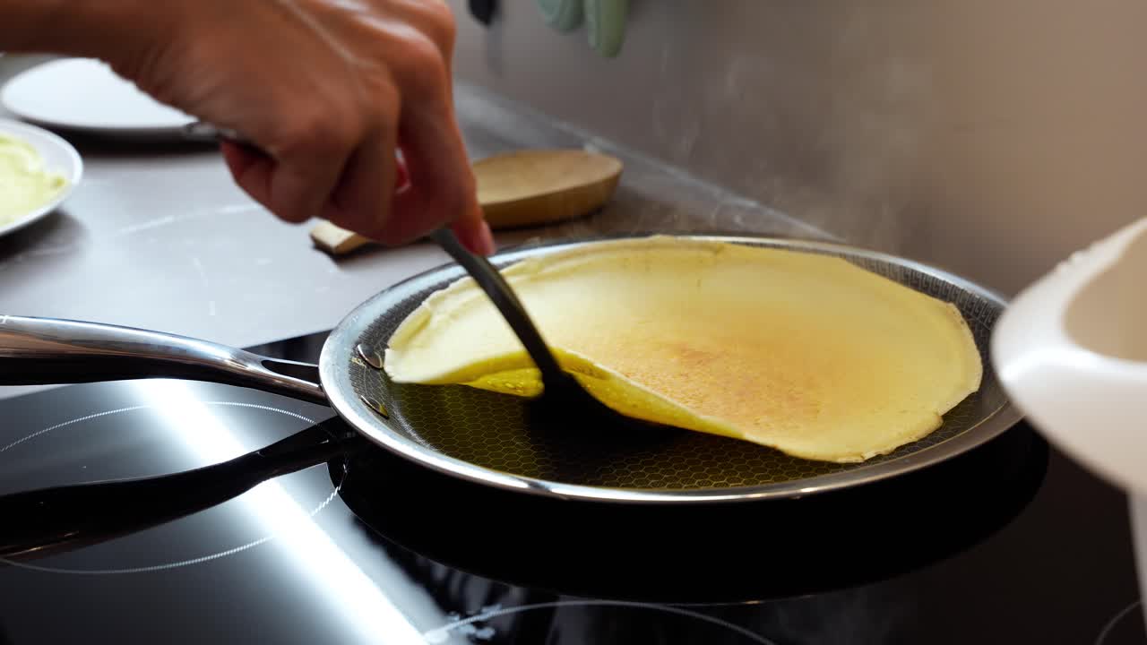 Pancakes, European-style, being cooked in a professional frying pan