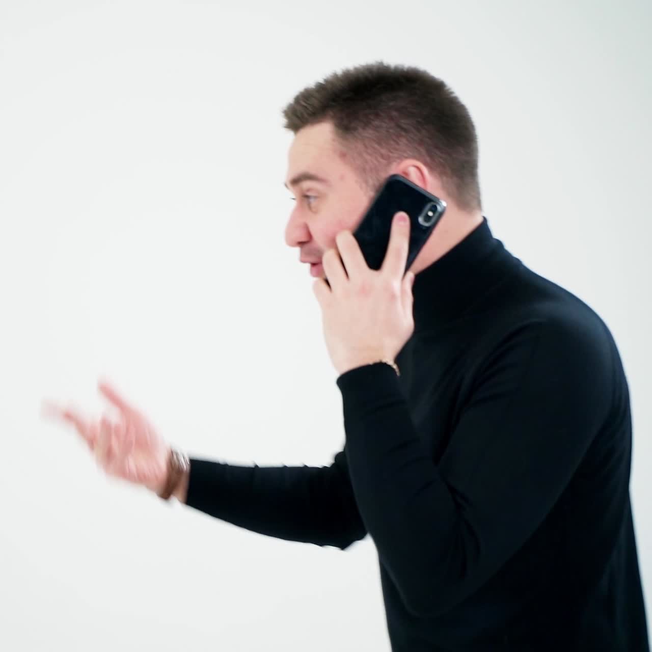 Happy young man talking on mobile phone. Businessman with a phone isolated over light background. Social distancing and self isolation in quarantine lockdown.