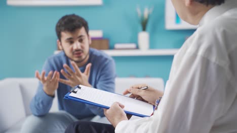 sad and depressed young man talking to therapist, getting psychological support.