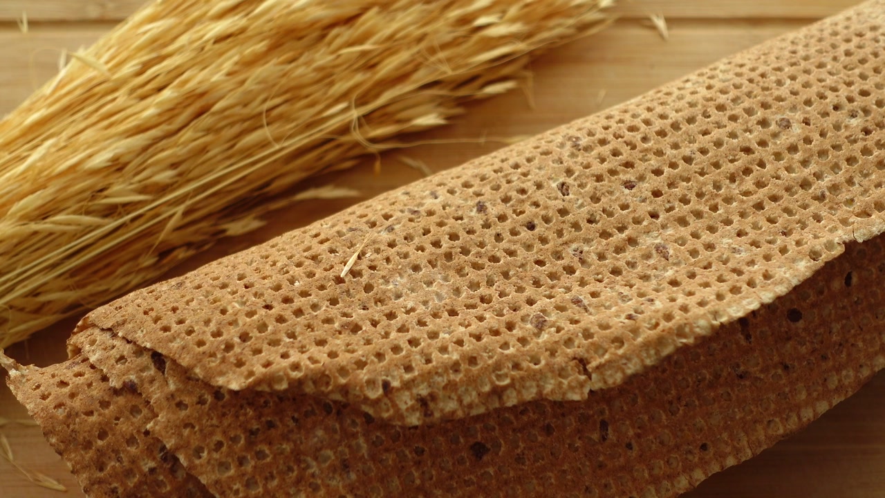 Rolled Crispy Flatbread with Wheat on Wooden Background