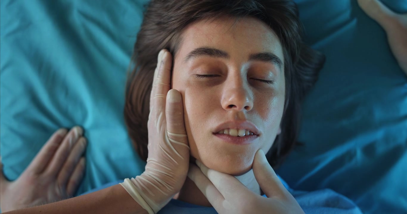 Professionista medico che esamina il viso e il collo di una giovane paziente