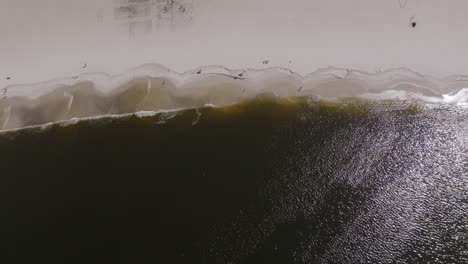 Aerial-flyover-of-the-beach-in-Botafogo-Bay-in-Rio-de-Janeiro-with-waves-and-people-playing-volleyball