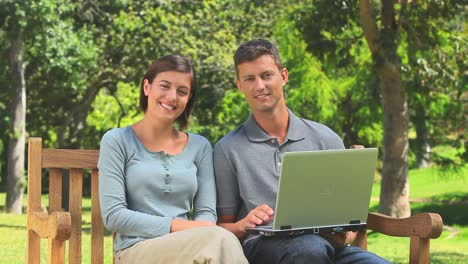 una joven pareja navegando en su computadora portátil