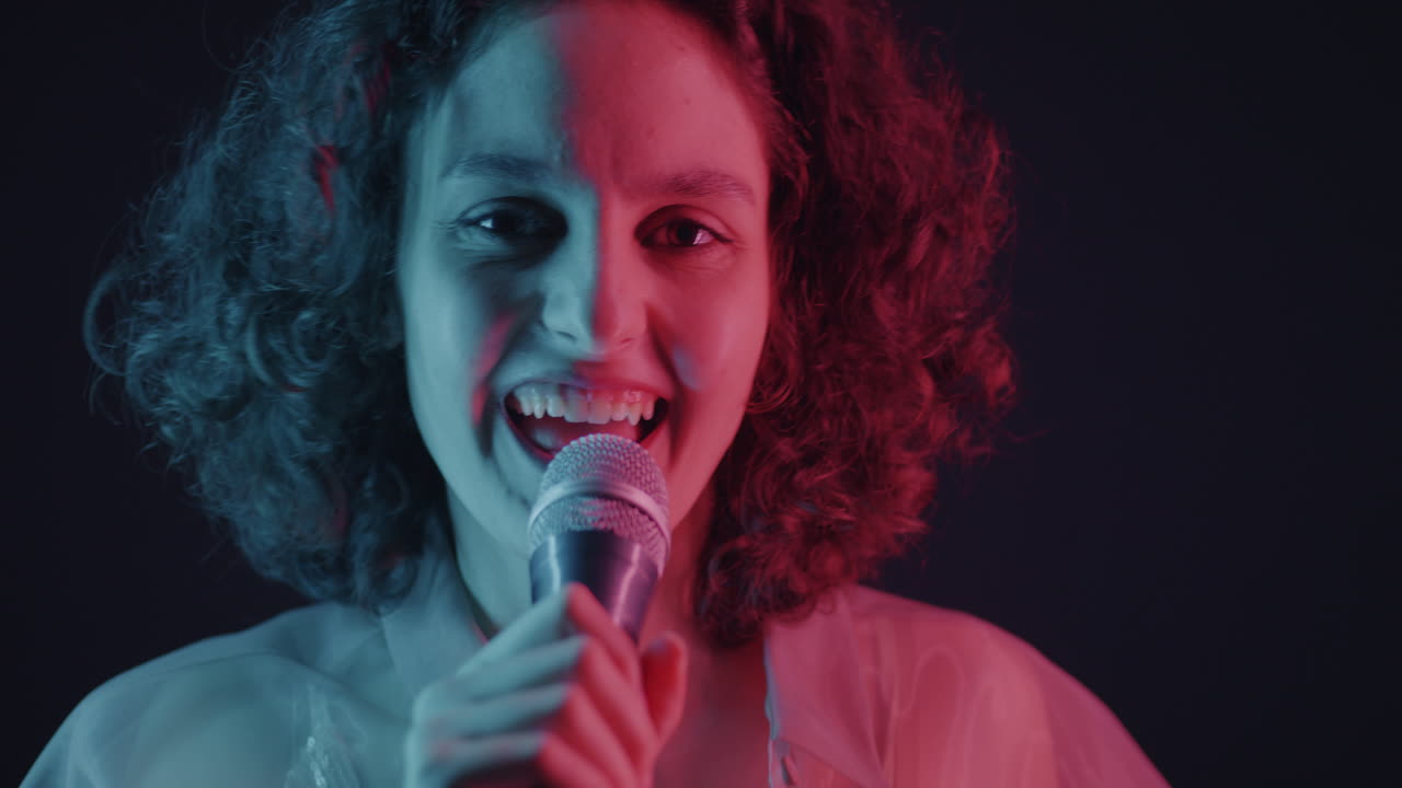 Woman Singing into a Microphone with Neon Lighting