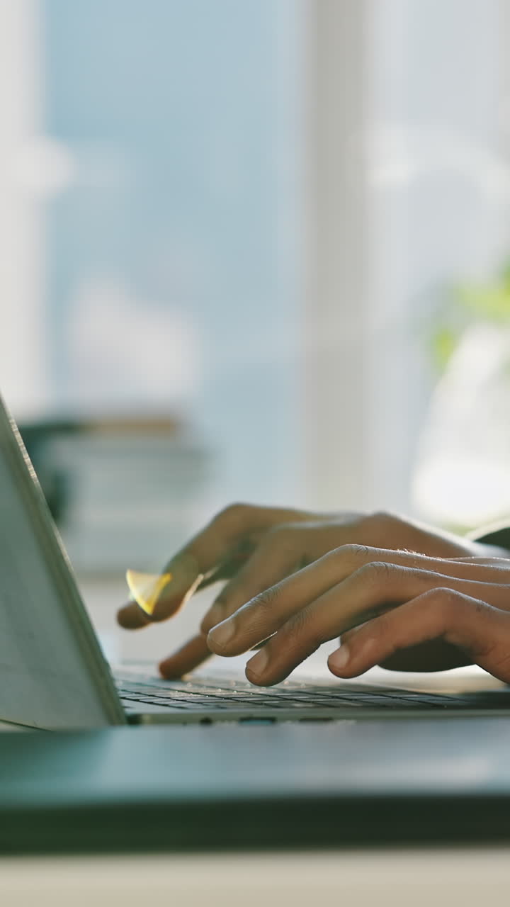 Close-Up of Hands Typing on Laptop Keyboard in Bright Office