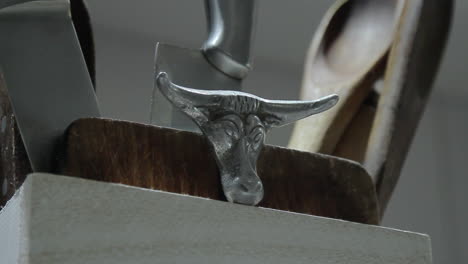 Slow-pan-of-dark-menacing-knife-arrangement-with-cow-head-symbolizing-meat-industry