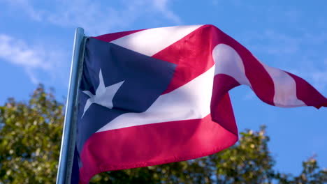 Bandera-Puertorriqueña-Ondeando-En-Cámara-Lenta-Contra-Un-Fondo-De-Cielo-Azul