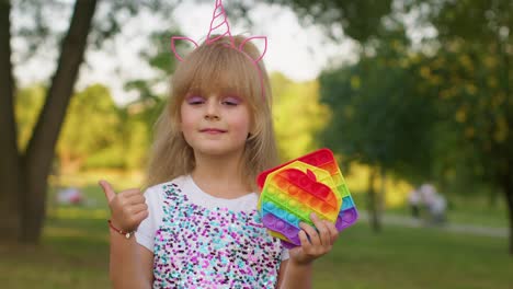 niños niña niño sosteniendo pop it juguetes sensoriales, de moda inquietante juego de burbujas de silicona contra el estrés