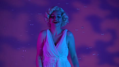 young woman surrounded by soap bubbles in studio on pink background with highlights illuminated by young woman surrounded by soap bubbles in studio on pink background with highlights illuminated by pink and green neon light woman looking like excitedly saying wow emotion joy childhood