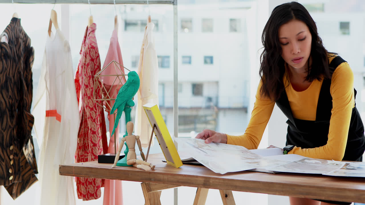 diseñador de moda mirando dibujos de vestidos 4k