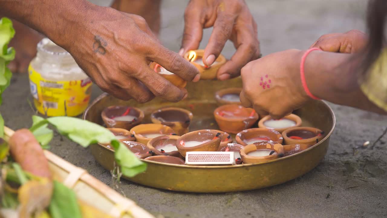 Famiglia indiana che accende diya per la Puja