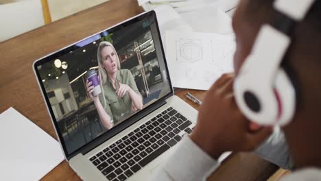 Estudiante-Universitario-Afroamericano-Sosteniendo-Notas-Mientras-Realiza-Una-Videollamada-En-Una-Computadora-Portátil-En-Casa