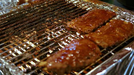 close up ribs with sauce on barbecue grill food night market, bangkok